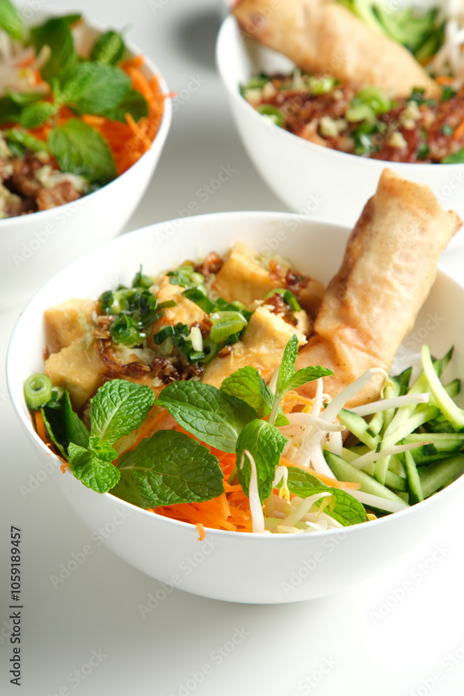 A variety of Bun Cha Gio bowls on a white countertop. A variety of Bun Cha Gio bowls on a white countertop.