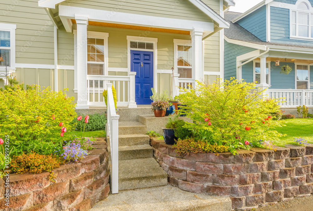 Obraz premium Entrance of grey painted luxury house in summer with stair steps and nice landscape in Vancouver, Canada, North America. Day time on June 2024