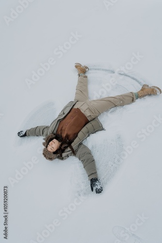 Happy woman in winter forest, enjoying the first snow. A young woman in a hat is having fun in the winter natute. Lifestyle.