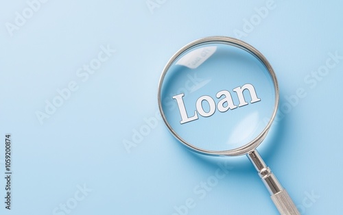 Magnifying glass highlighting word "Loan" text on blue background, symbolizing detailed loan analysis, financial inspection, and borrowing decisions