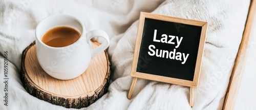 Cozy coffee cup next to a wooden sign on a soft blanket, embodying a lazy Sunday vibe. photo