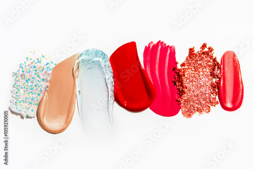 Set of cosmetic texture smears on a light background, including eyeshadow, lipstick, and glitter. Beauty products, vibrant and varied textures.