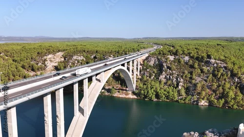 Aerial view of the arch Krka bridge and a highway with road traffic beneath. Travelling across Croatia in summer photo