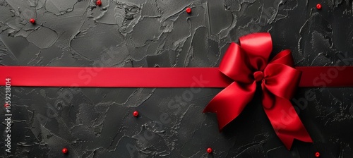 Red Satin Ribbon Bow on Black Textured Surface