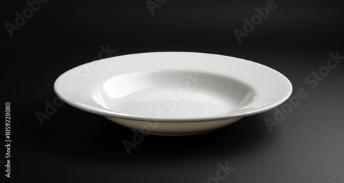 Simple white ceramic plate on a dark background showcasing elegant design and...