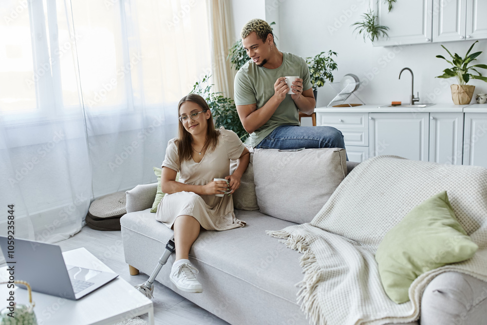 Two friends share laughter and drinks in a bright, modern living space. Two friends share laughter and drinks in a bright, modern living space.