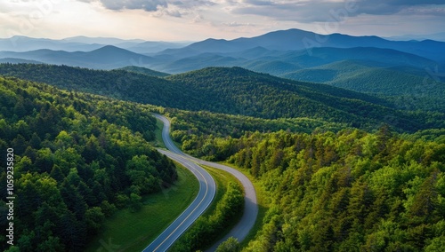 Aerial View of Winding Asphalt Road Through Lush Green Forest and Mountains in Summer, Bird's-Eye Perspective in Europe, Landscape Photography