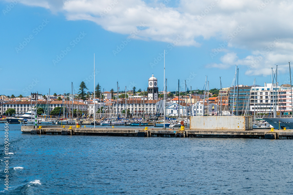 A view from a boat past the harbor wall at Ponta Delgada on the island of San Miguel in the Azores in summertime A view from a boat past the harbor wall at Ponta Delgada on the island of San Miguel in the Azores in summertime