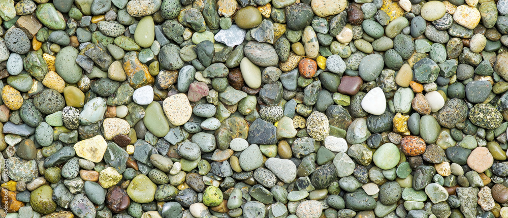 A close-up view of a variety of colorful pebbles and stones creating a natural textured background. A close-up view of a variety of colorful pebbles and stones creating a natural textured background.