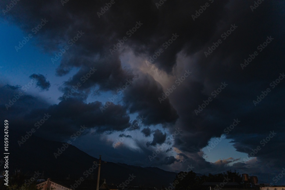 Dramatic storm clouds over mountain landscape at dusk. Dramatic storm clouds over mountain landscape at dusk.