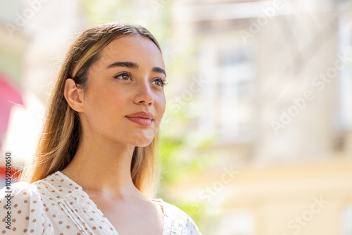 Close-up portrait of happy young woman face smiling friendly open eyes glad expression looking away dreaming resting relaxation feel satisfied good news outdoors. Pretty adult lady on city street.