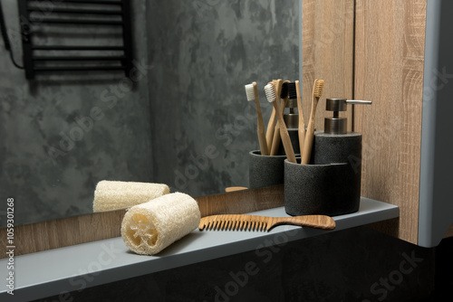Eco-friendly bathroom essentials on a sleek shelf: bamboo toothbrushes, wooden comb, and natural loofah. Concrete holders and a soap dispenser add a touch of modern minimalism