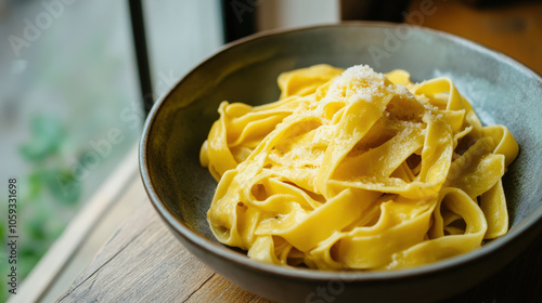 A bowl of pasta with cheese on top