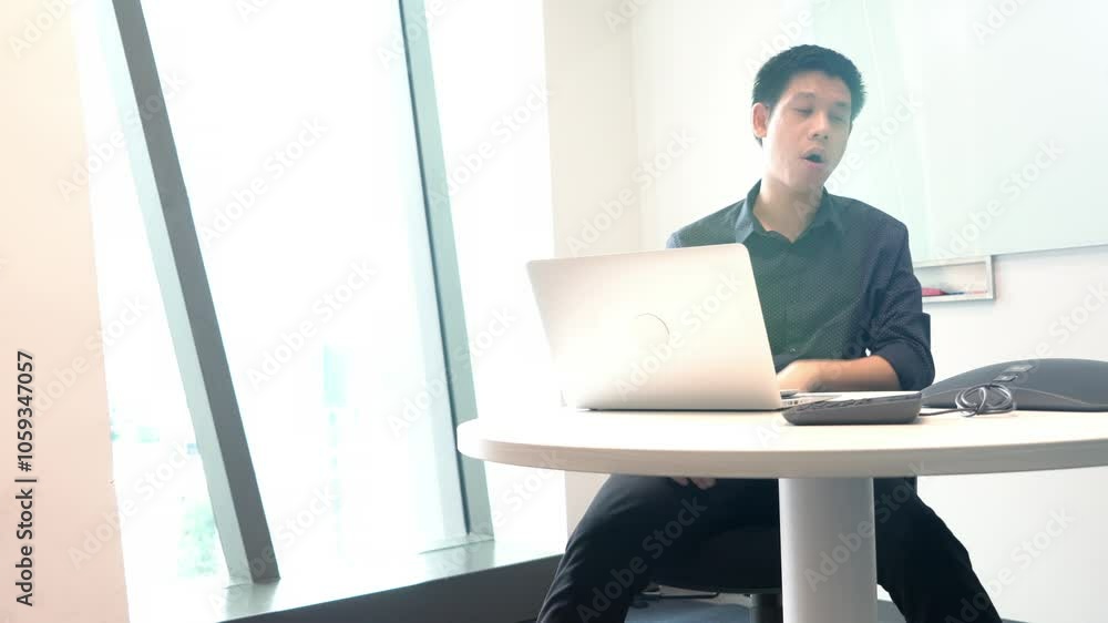 A man stands in front of a white board with a laptop on a table behind him. He is holding a marker and he is preparing to write on the board A man stands in front of a white board with a laptop on a table behind him. He is holding a marker and he is preparing to write on the board