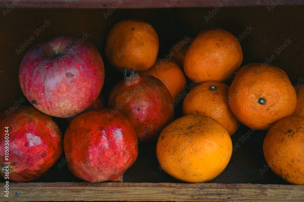 Apples, pomegranates, and oranges on a rustic wooden shop shelf that shows the candid daily life moment and local small business in Pokhara Nepal Apples, pomegranates, and oranges on a rustic wooden shop shelf that shows the candid daily life moment and local small business in Pokhara Nepal