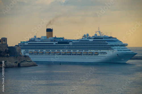 Modern Italian family cruiseship cruise ship liner Fascinosa morning arrival into port of Valletta, Malta with old town skyline and harbor entrance photo