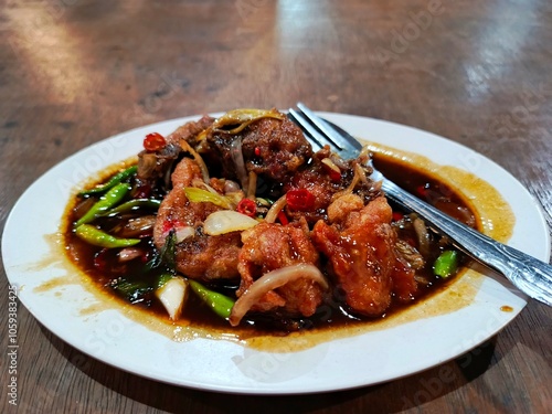 close up of delicious soy sauce chicken sitting on a white plate. photo