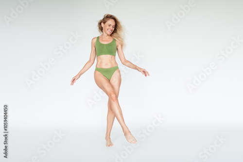 Full length photo of mature blonde lady posing have fun dressed khaki lingerie white background no filter self acceptance all body perfect