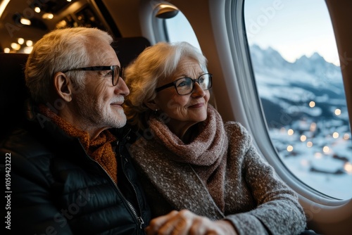 An elderly couple seated in an airplane, gazing contentedly out the window at the snow-capped mountains below, evoking a sense of nostalgia and adventure together. photo