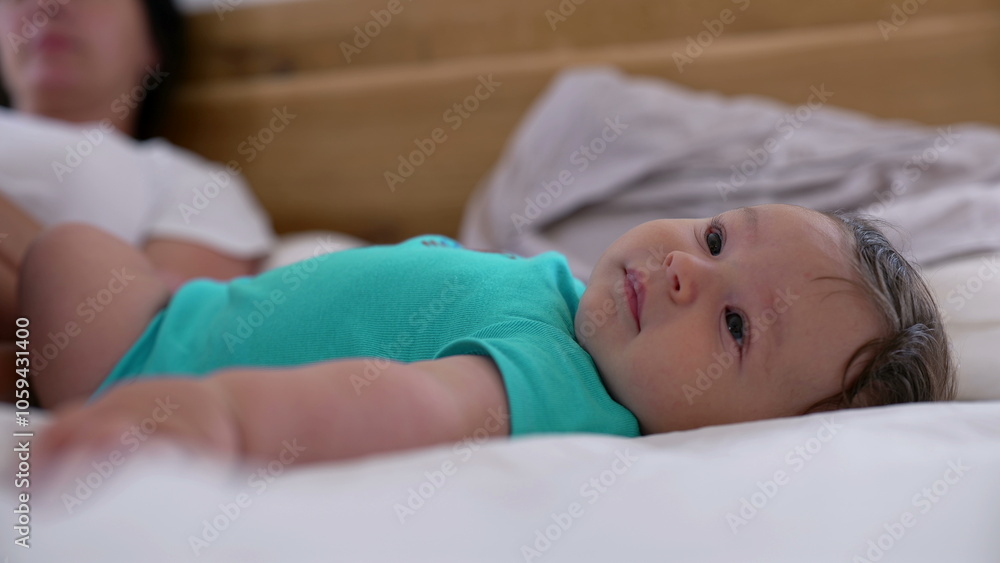 Close-up of a smiling baby lying on a bed, enjoying a peaceful moment in a relaxed family home environment Close-up of a smiling baby lying on a bed, enjoying a peaceful moment in a relaxed family home environment