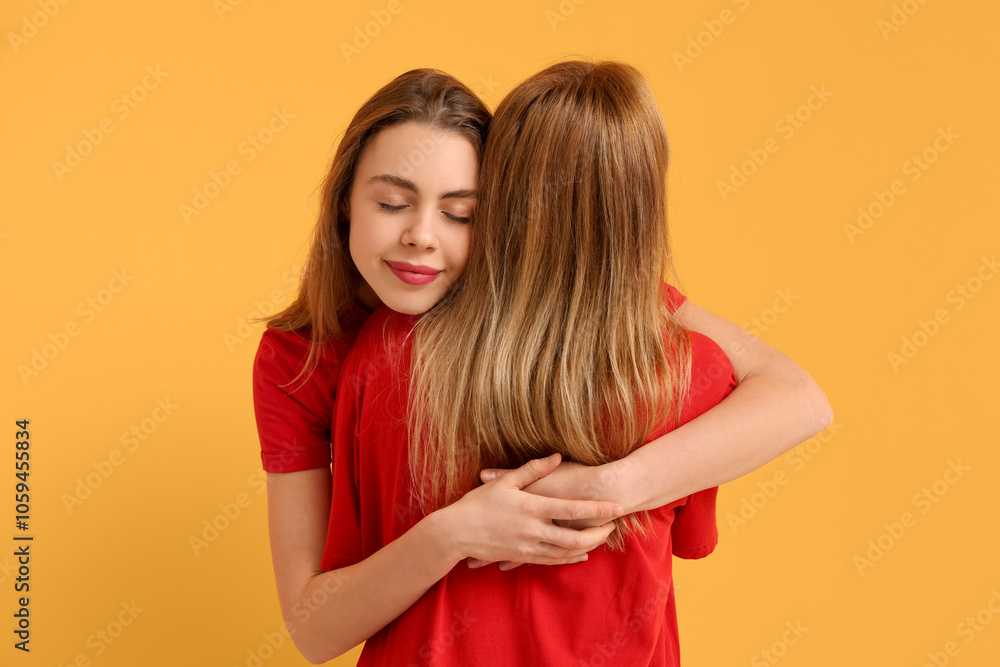 Beautiful young woman hugging her mother on yellow background. International Hug Day Beautiful young woman hugging her mother on yellow background. International Hug Day