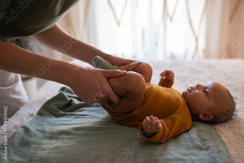 Parent helping newborn to relieve gas photo