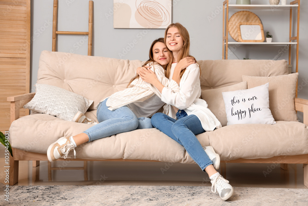 Young women hugging on sofa at home Young women hugging on sofa at home