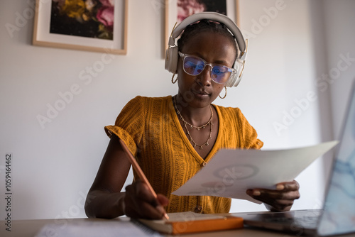 Businesswoman taking notes while studying financial report photo