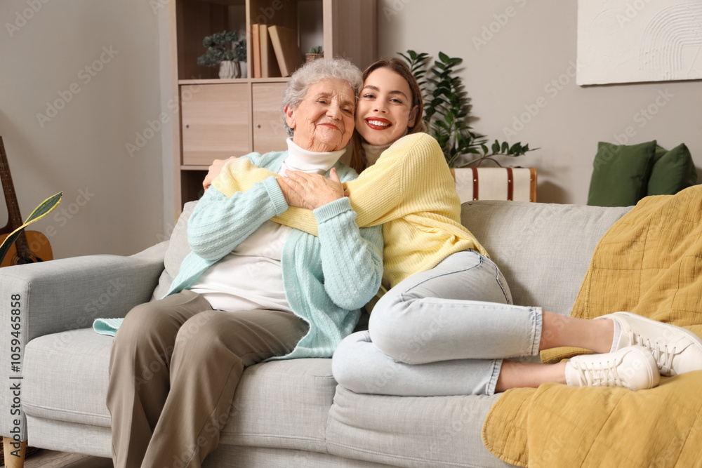 Young woman hugging her grandmother on sofa at home Young woman hugging her grandmother on sofa at home