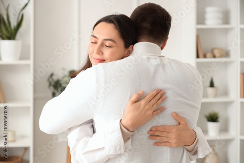 Happy young woman hugging her husband at home