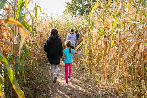 A group of young sisters walking in a corn maze, surrounded by stalks