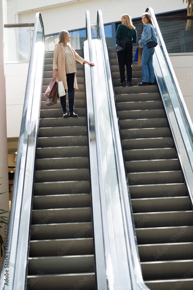 Grandmother looking at mother and daughter while going on escalator Grandmother looking at mother and daughter while going on escalator