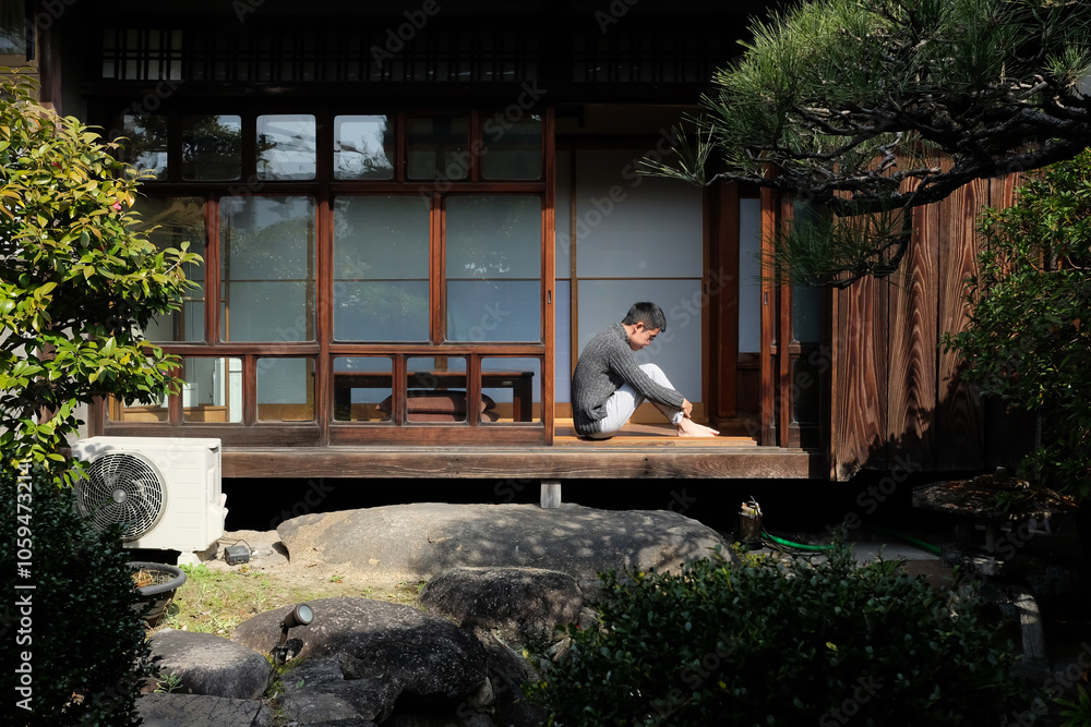 Depression man sitting huddled lonely at backyard Depression man sitting huddled lonely at backyard