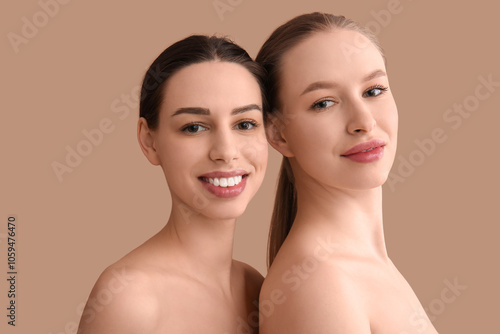 Beautiful young sisters on brown background