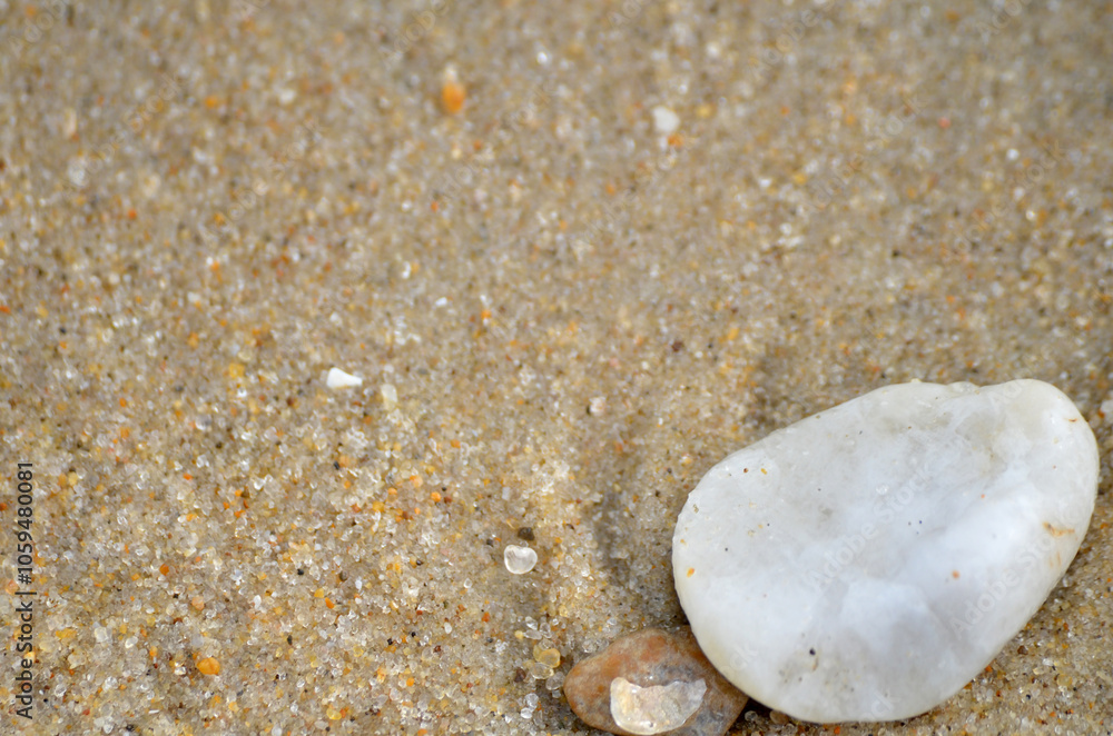 Granite tumbled rocks on sandy ocean beach close up Granite tumbled rocks on sandy ocean beach close up