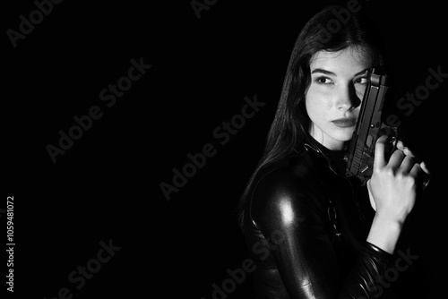 Female spy with gun on dark...