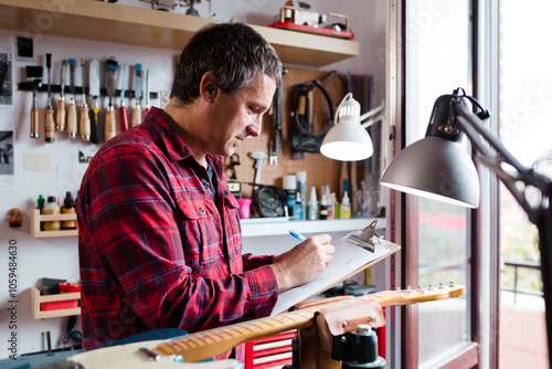 Guitar luthier checking pending reparations photo