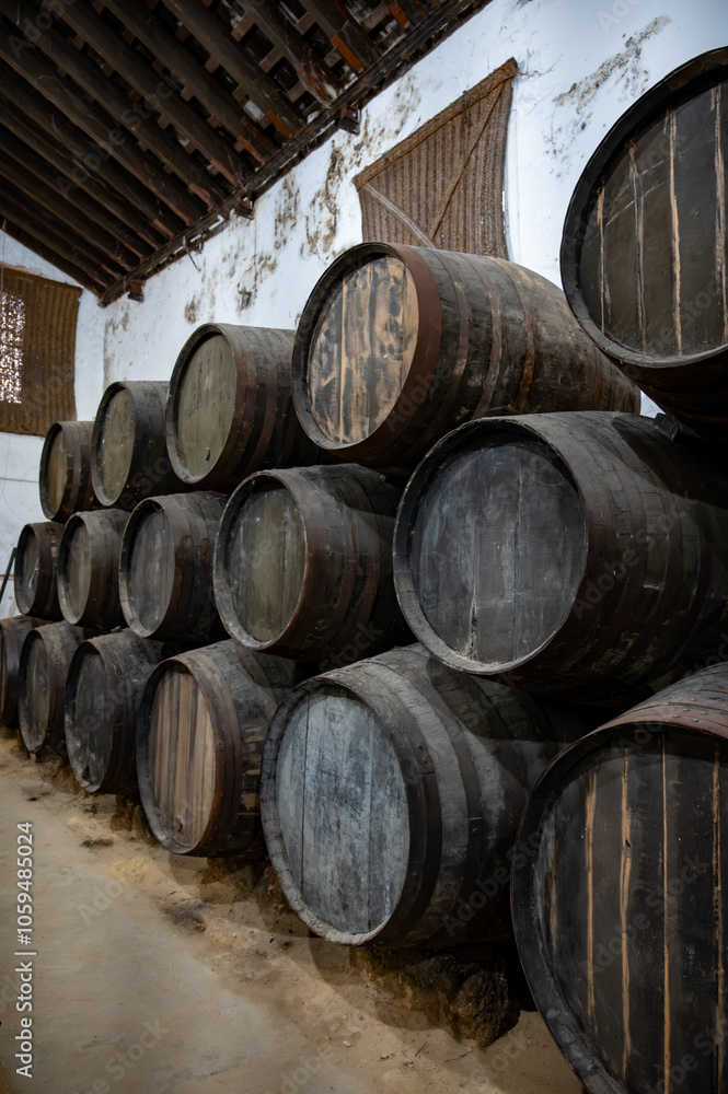 Solera system in old Andalusian wine cellar, process for aging sherry wine in barrels, fino, manzanilla, olorosso, amontillado jerez fortified wine, Sanlucar de Barrameda, Cadiz, Andalusia, Spain Solera system in old Andalusian wine cellar, process for aging sherry wine in barrels, fino, manzanilla, olorosso, amontillado jerez fortified wine, Sanlucar de Barrameda, Cadiz, Andalusia, Spain