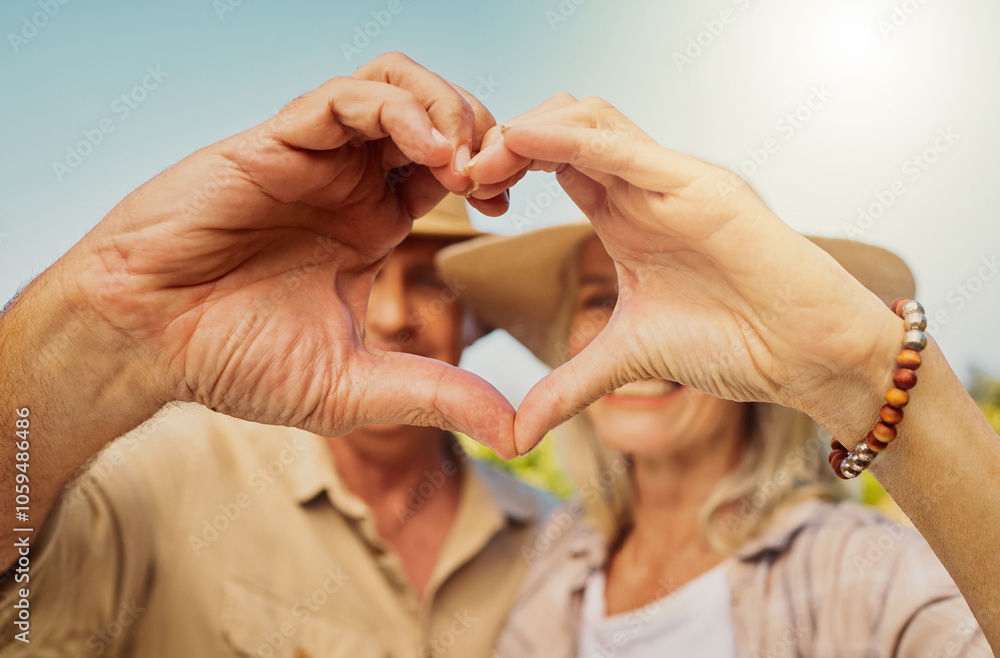 Fototapeta premium Couple, happy and love sign by nature for relationship, holiday and bonding together on date with hug. Mature, people and heart hands countryside farm for romance, vacation and embrace with sunshine