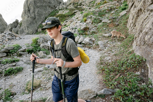 young hiker meeting a chamois, or wild goat,  in the French Alps photo