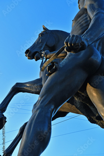 famouse horse sculpture against blue sky: The Horse Tamers, designed by the Russian sculptor, Baron Peter Klodt von Urgensburg. Anichkov bridge, Saint-Petersburg, Russia photo