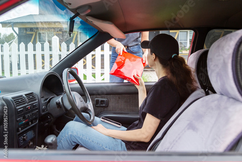 Courier Receiving Envelope from Customer Through Car Window photo