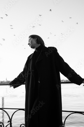 Black and white artistic photo of a model posing in front of a lake  photo