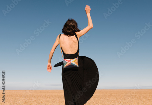 Woman in Black Dress Enjoying Sunny Beach Freedom photo