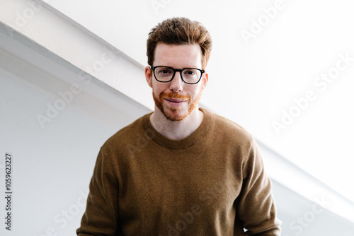 Portrait of a red-haired bearded man confidently looking at camera