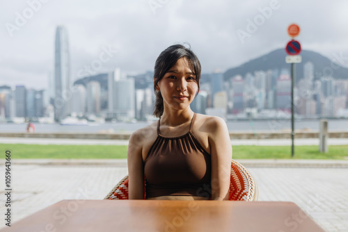 Woman Sitting at an Outdoor Cafe with City Skyline