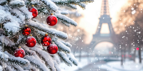 Christmas tree covered with snow and decorated with red baubles in Paris, France.