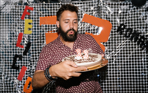 Man Blowing Out Birthday Candles on Cake photo