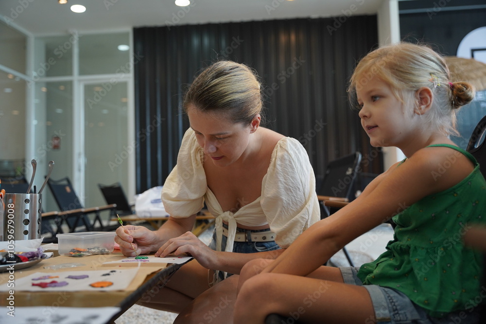 Obraz premium Mother and her daughter paint Halloween cookies 