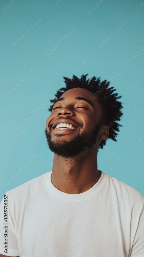 Fototapeta premium Happy Young Man with Natural Hair Against a Teal Background